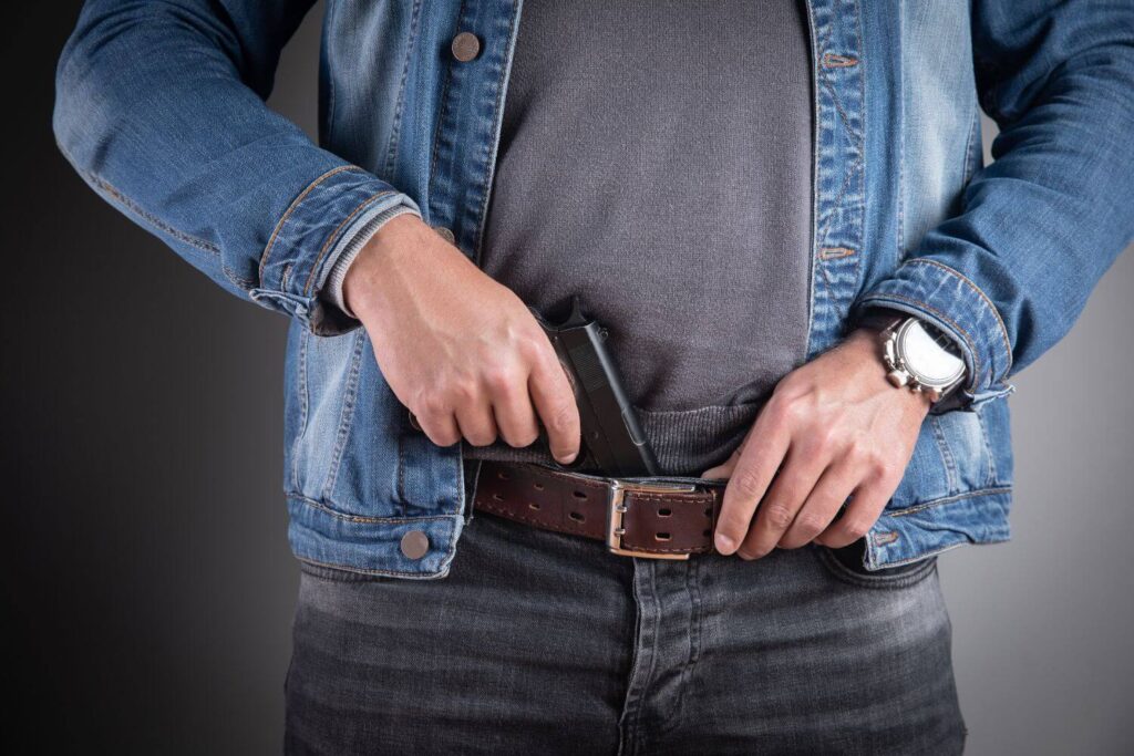 Man holstering his pistol inside the waistband